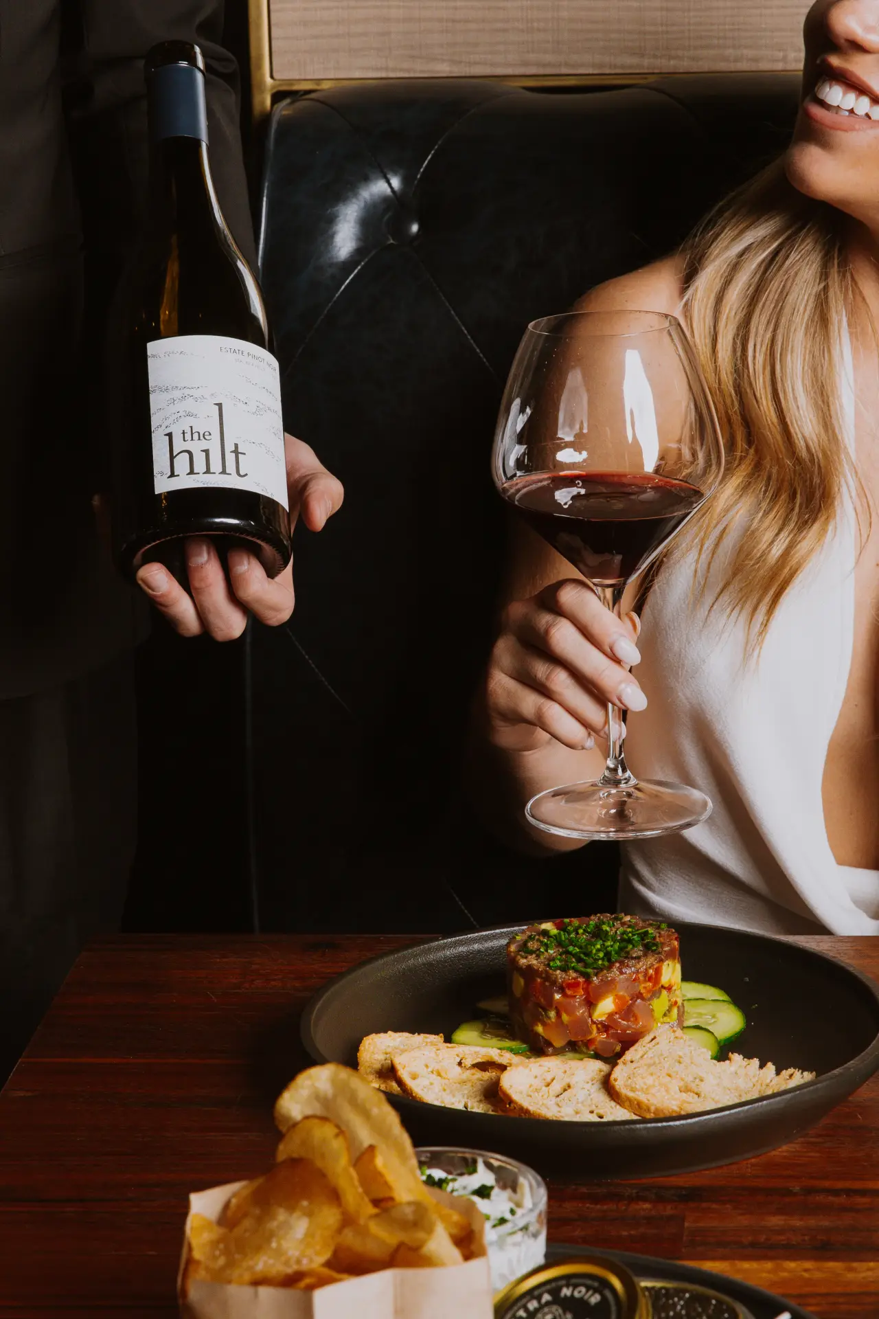 A guest with a glass of red wine
